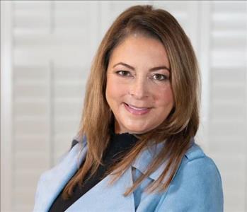 Woman with brown hair in blue jacket